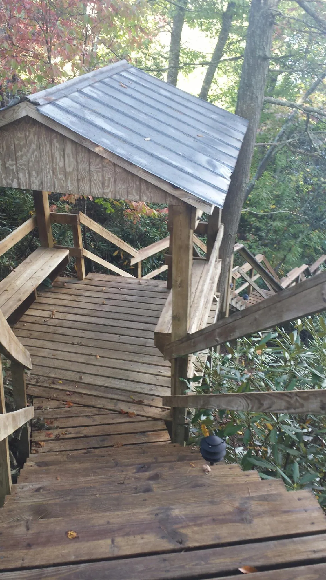 Metal roofed shelter over wooden steps on a wooded walkway — Skylight Repair & Installation work by our crew in Glen Aubrey