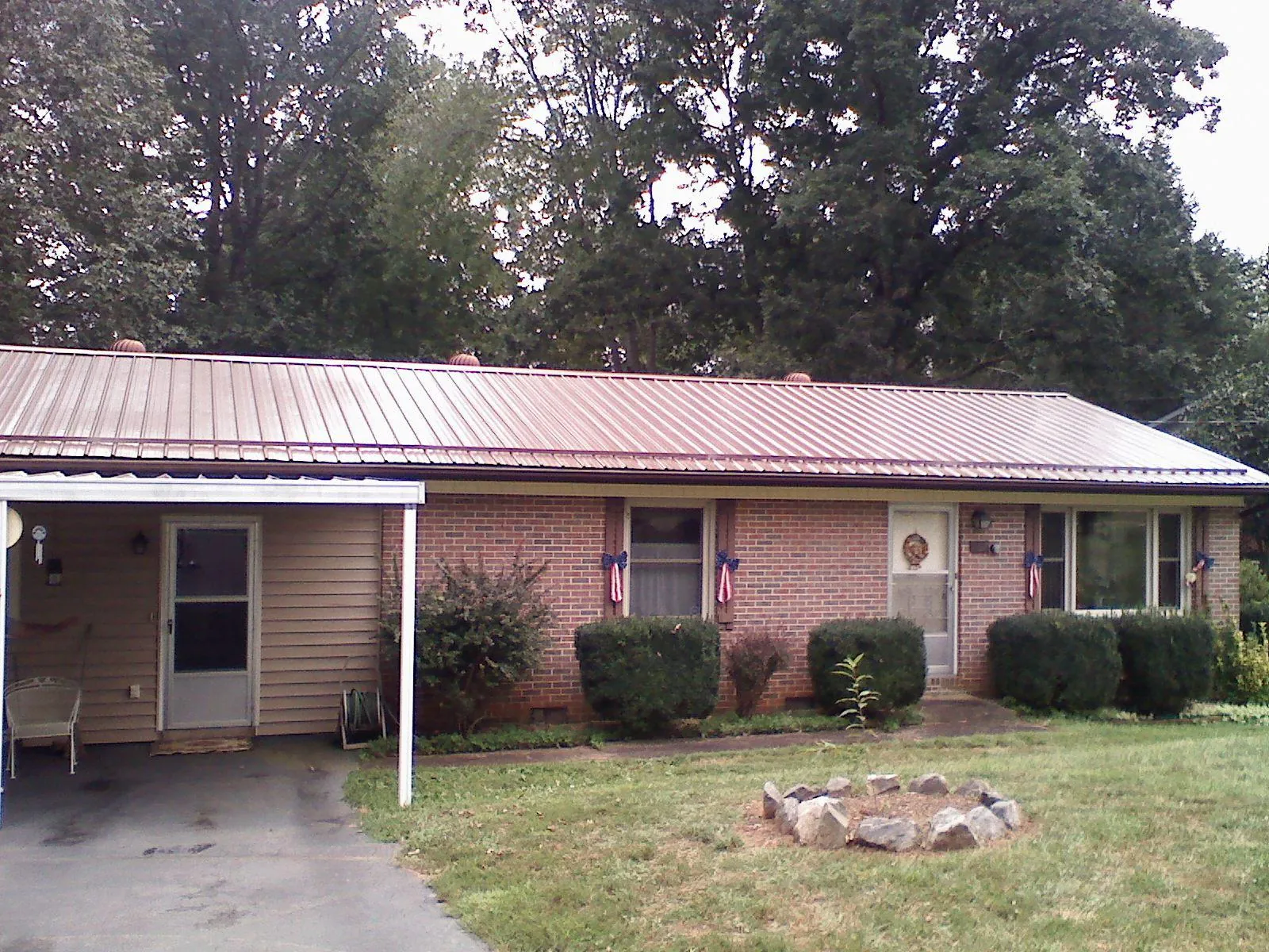 Bronze metal roof and carport on a brick ranch home — Roof Repair work by our crew in Glen Aubrey